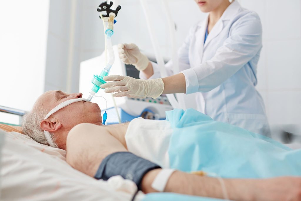 Pflegekraft betreut beatmeten Patienten mit Tracheostoma in häuslicher Umgebung – Intensivpflege Mülheim